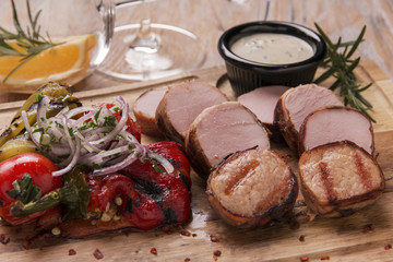 Pork steaks grilled cut on a wooden board with vegetables