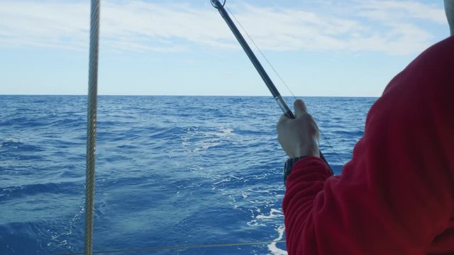 Part of man's body fishing from yacht board