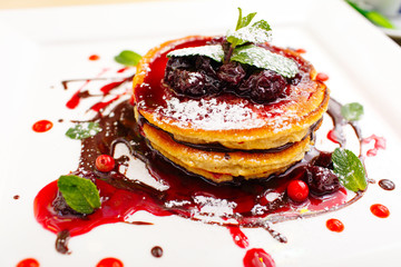 pancakes fritters with chocolate topping blackberries and cranberries