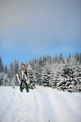 Happy young woman walking in winter time. Happy girl having fun in the snow. Snow covered trees in the winter sun light. Snowy pine trees on a winter landscape. snovy trees on winter mountains