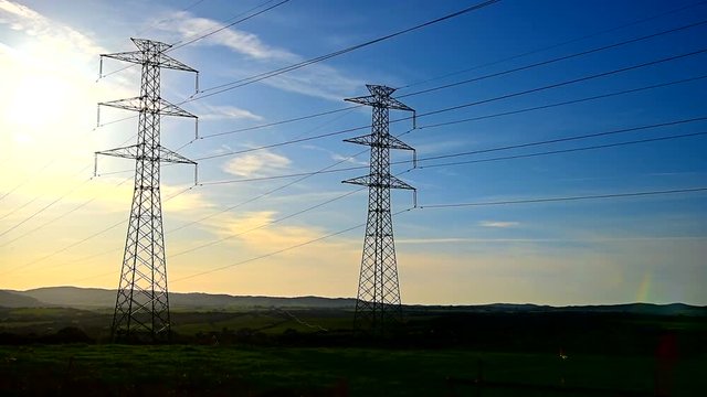 Power towers in the countryside at sunset