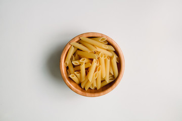 Dried rigatoni pasta in wooden bowl