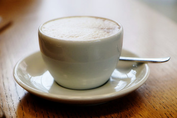 delicious cappuccino cup on wooden table with soft focus and  blurred background