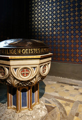 Munich, interior of St. Louis University church - Ludwigskirche built in XIX century in Neo-Romanesque style, view of the decorated baptismal font and the golden painted wall