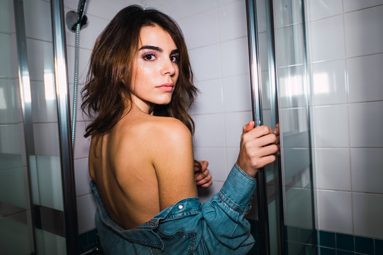 Seductive woman undressing in bathroom