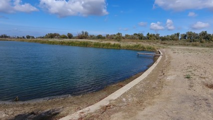 An artificial lake for fishing. A bridge for fishermen on the lake. Lake fishing