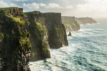 The Cliffs of Moher, Irelands Most Visited Natural Tourist Attraction, are sea cliffs located at the southwestern edge of the Burren region in County Clare, Ireland. - obrazy, fototapety, plakaty
