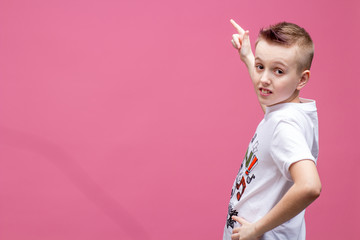 Smiling boy pointing at the left with his finger and much of empty space