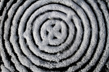 Fototapeta na wymiar Abstract image similar to the Celtic cross of snow. Snowy ornament of large and small circles.