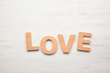 Word LOVE made of letters on wooden background