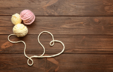 Heart made of thread on wooden background