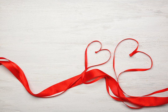 Hearts made of ribbons on wooden background