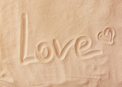 Word LOVE written on sand