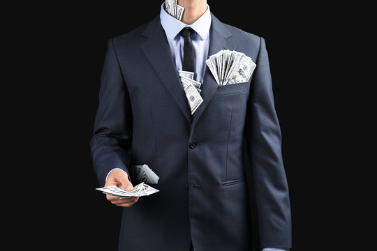 Businessman with money on dark background. Corruption concept