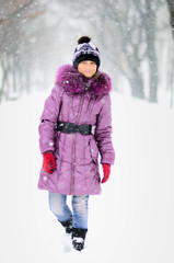 happy girl teenager in the purple coat in winter