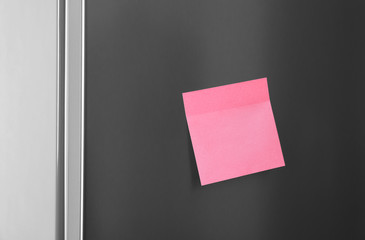 Blank sticky note on refrigerator door