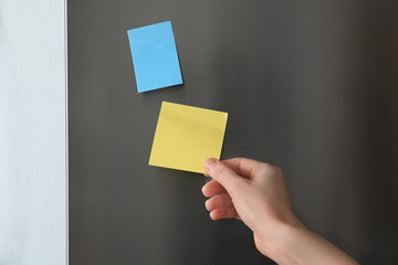 Woman touching paper sheet on refrigerator door © Africa Studio