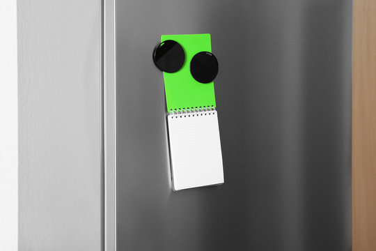 Notebook and magnets on refrigerator door