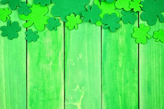 St Patricks Day top border of shamrocks over a green wood background