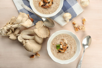 Bowl with delicious mushroom soup on wooden table