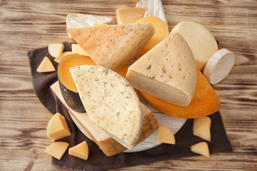 Different types of delicious cheese on wooden table