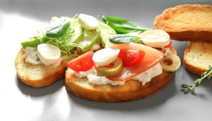 Tasty bruschettas with prosciutto on plate, closeup