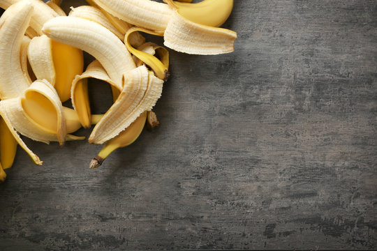 Ripe peeled bananas on grey background