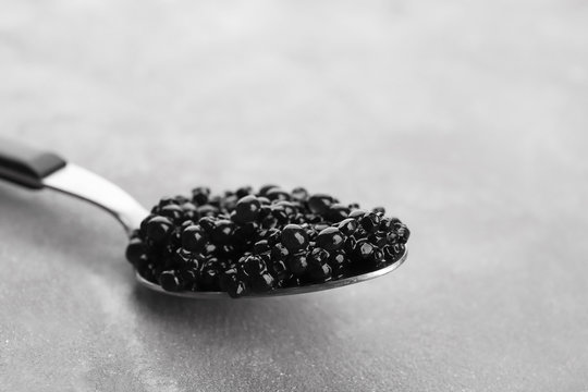 Black caviar in spoon on table