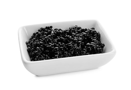 Black caviar in ceramic bowl on white background