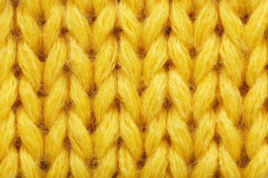 Yellow knitted fabric texture as background, closeup