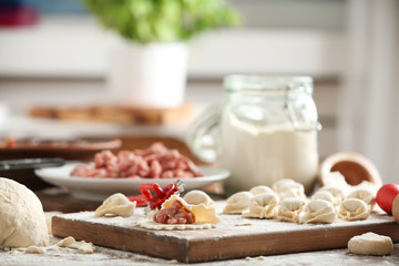 Raw meat dumplings on wooden board