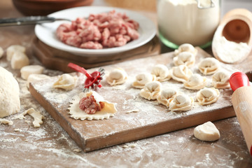 Fototapeta na wymiar Raw meat dumplings on wooden board