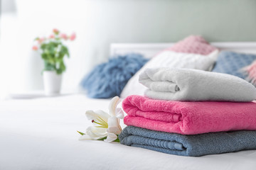Obraz na płótnie Canvas Stack of clean towels on bed