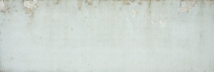 Fototapeta premium The texture of the old wall, decorated with a lot of square small tiles. Wall in the style of architecture of the Soviet Union