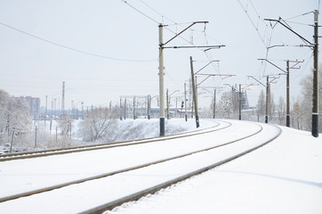 Naklejka premium Zimowy krajobraz kolejowy, tory kolejowe w ośnieżonym kraju przemysłowym