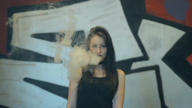 Young girl smokes in the underpass.