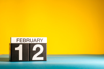 February 12th. Day 12 of february month, calendar on yellow background. Winter time. Empty space for text
