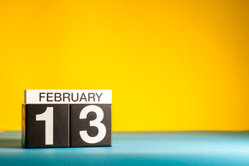 February 13th. Day 13 of february month, calendar on yellow background. Winter time. Empty space for text