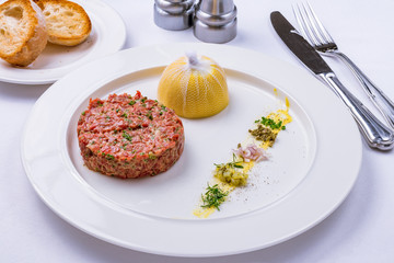 tartare from beef on a white plate