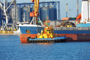 Tugboat assisting bulk cargo ship