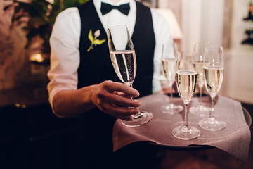 waiter brings glasses of champagne