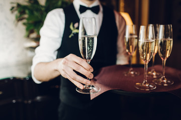 waiter brings glasses of champagne