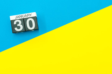 January 30th. Day 30 of january month, calendar on blue and yellow background flat lay, top view. Winter time. Empty space for text