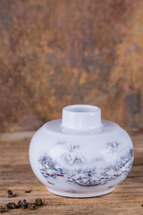 Traditional ceramic tea container with a lid. Brown background. Copy space. 