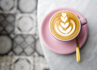 Cup of hot latte coffee on marble table background with art floor