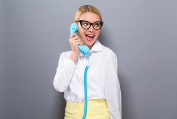 Young woman talking on old fashioned phone