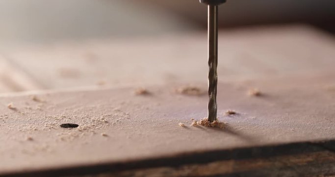 Electric driller on wooden plank