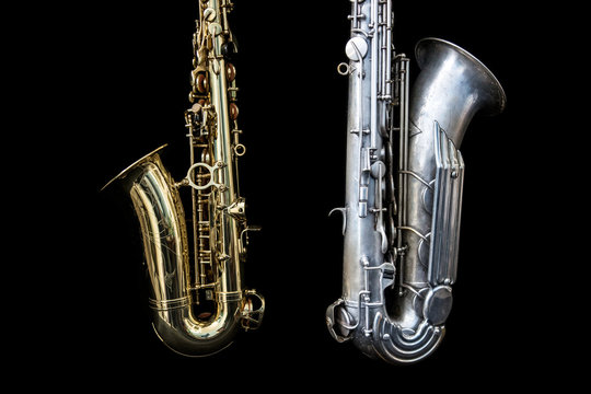 Close up of two saxophones standing isolated in black