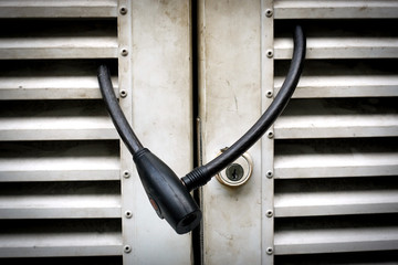 Cable lock on white old steel door