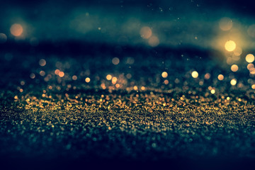 Sprinkle glitter gold dust in the dark with copy space